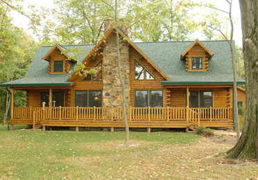 Cedar log home with stone chimney and porch