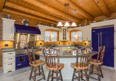 Log home kitchen with wooden beams and island