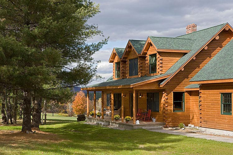 Cedar log home with green roof and dormers