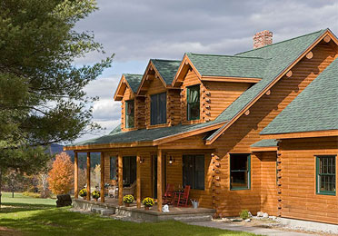 Log home with green roof and large front porch