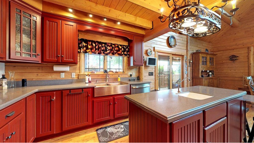 Rustic kitchen with red cabinets and wooden ceiling