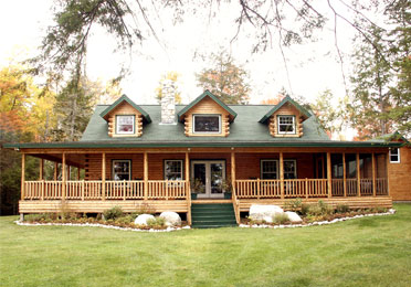 Log home with green roof and large porch