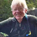 Smiling man outdoors with glasses and backpack