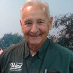 Smiling man in green shirt with Ward logo