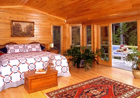 Bedroom with wooden walls, hardwood floor, and large windows