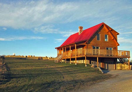Wooden log cabin with red roof and large porch
