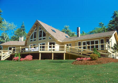 Large log cabin with triangular windows and wraparound deck