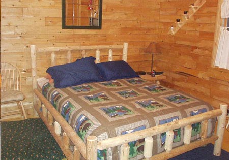 Log cabin bedroom with wooden walls and rustic bed.