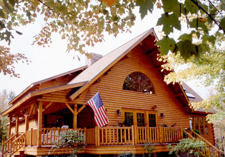Log home with wooden porch and American flag