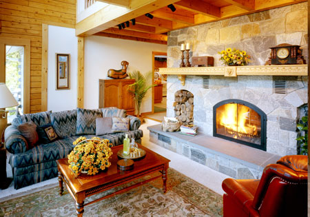 Living room with stone fireplace, wooden beams, and cozy seating