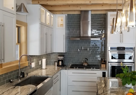 Contemporary kitchen featuring glass tile backsplash and modern appliances.