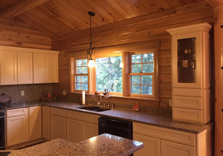 Wooden kitchen with granite countertops and large window