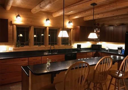 Log home kitchen with wooden beams and island
