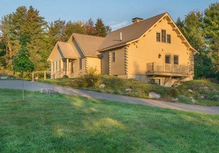 Cedar log home with sloped roof and balcony