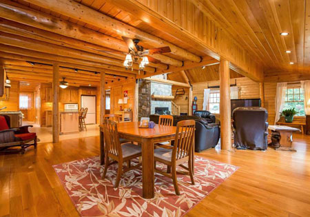 Open log home interior with dining table and chairs