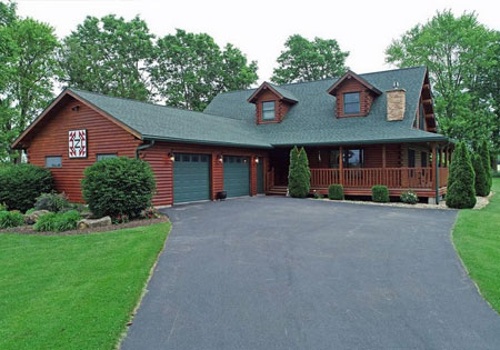 Log home with green roof surrounded by trees