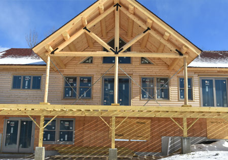 Partially built log home with wooden beams