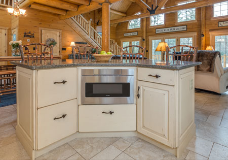 Log home kitchen with wooden beams and island