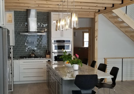 Kitchen with island, pendant lights, and timber beams