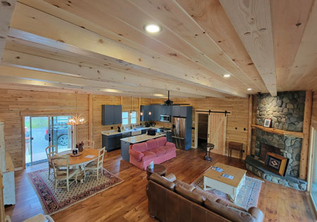 Spacious log home interior with kitchen and fireplace