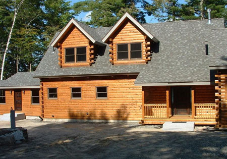 Log home with two dormer windows and wooden porch