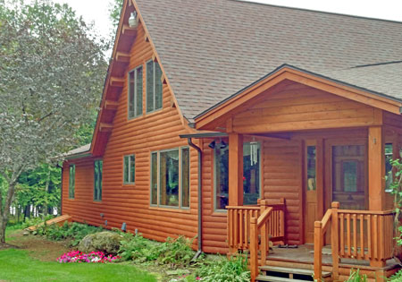 Cedar log home with large windows and porch