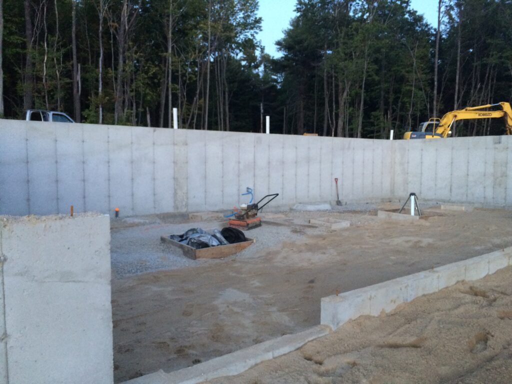 Concrete foundation with gravel base and construction equipment.