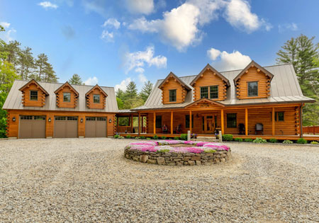 Large log home with stone landscaping and garage