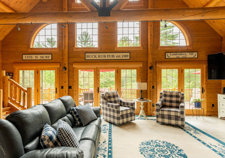Spacious log home living room with large windows and seating