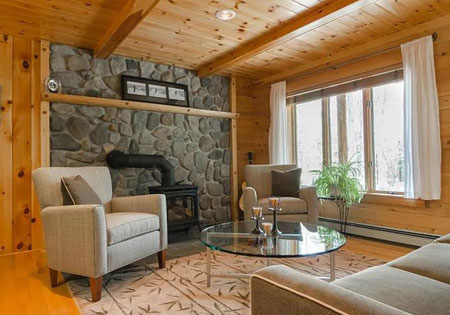 Living room with stone fireplace and wooden walls