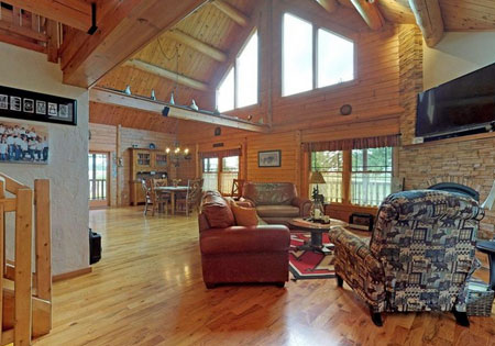 Large living room with wooden beams and stone fireplace
