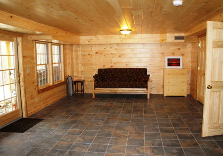 Wood-paneled basement with sofa and tiled floor