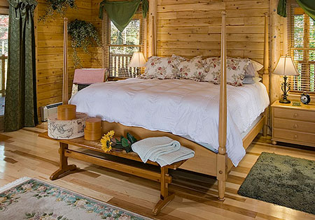 Log home bedroom with wooden bed and hardwood floor