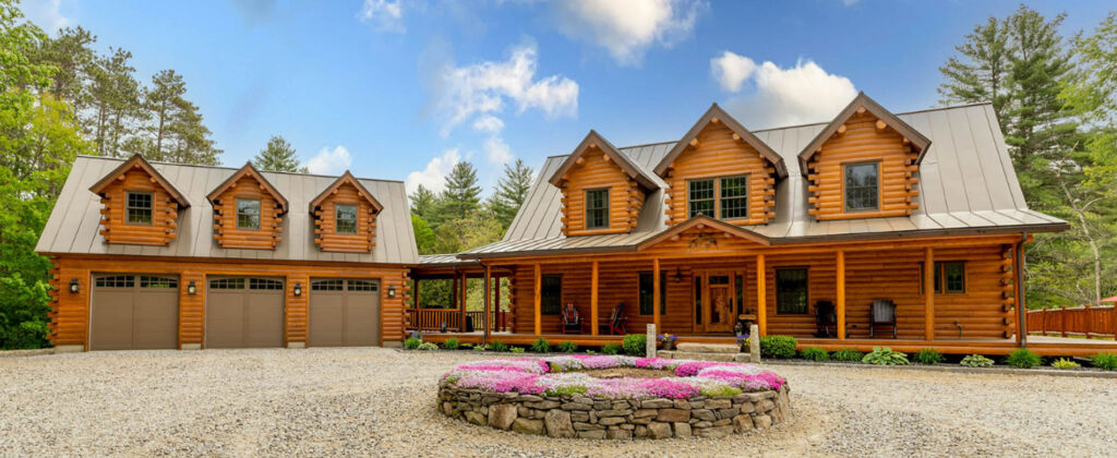 Front view of a large cedar log home with garage.