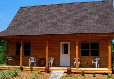 Cedar log cabin with a front porch and chairs