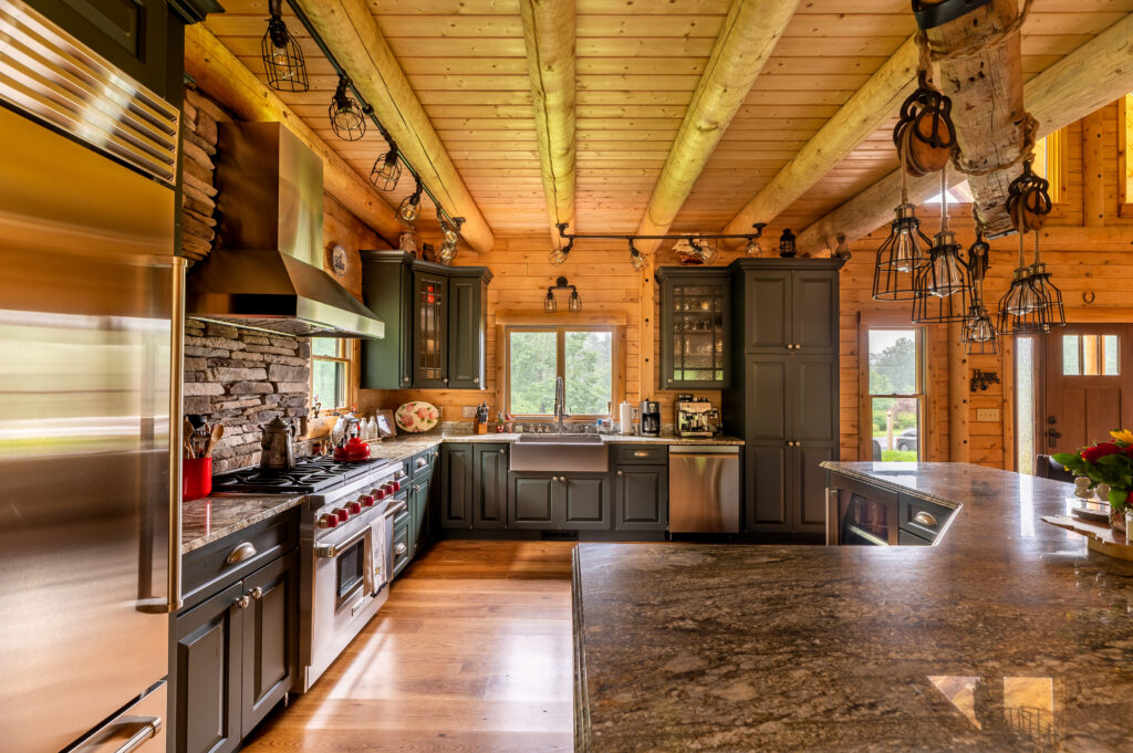 Spacious kitchen with wooden beams, stone wall, and modern appliances.