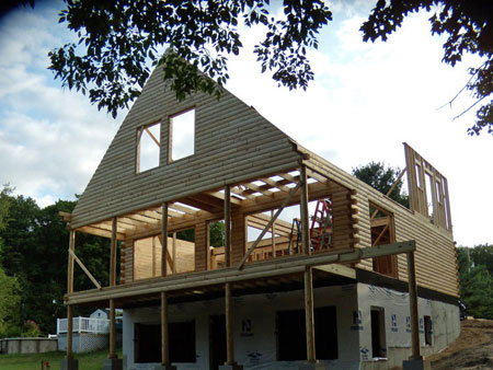 Partially built log home with wooden frame and open roof.