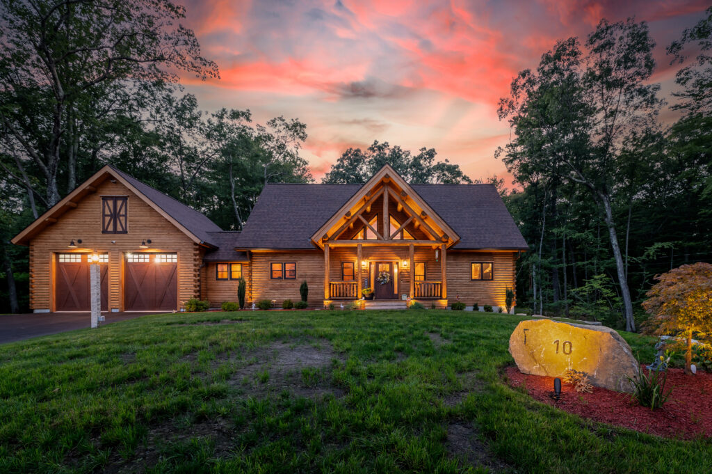 Log home with large porch and garage at sunset