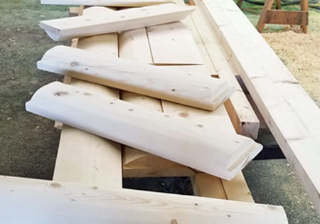 Several unfinished wooden log stair treads on a table.