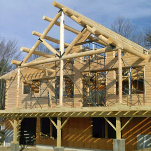 Partially built log home with exposed beams and scaffolding