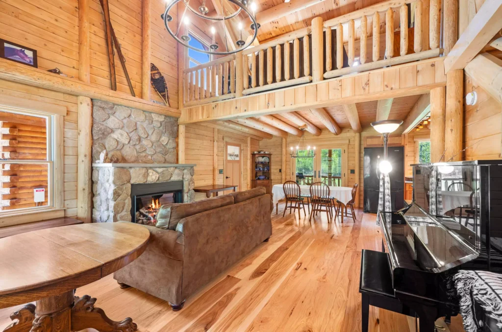 Spacious log cabin living room with fireplace and piano